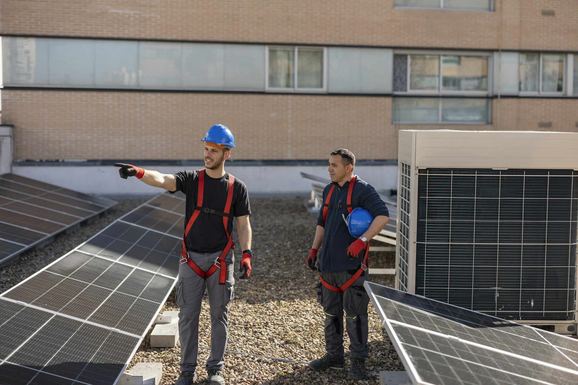 rooftop workers discuss how to place solar panels on the rooftop